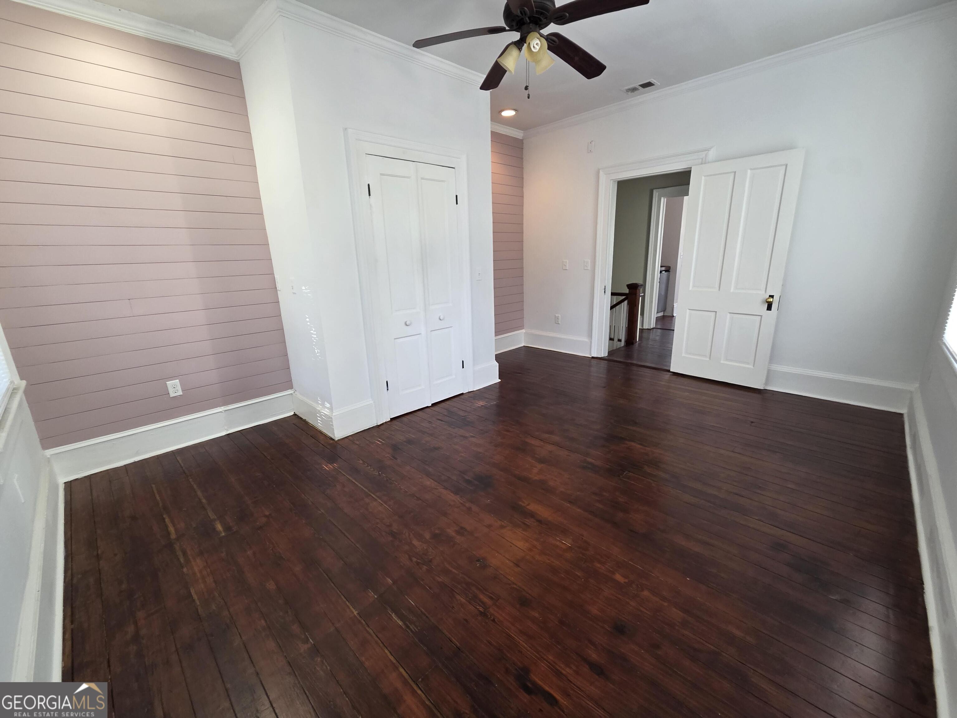520 Ellis Street Brunswick, GA 31520 - Photo 31 of 48 an empty room with wooden floor a ceiling fan and windows