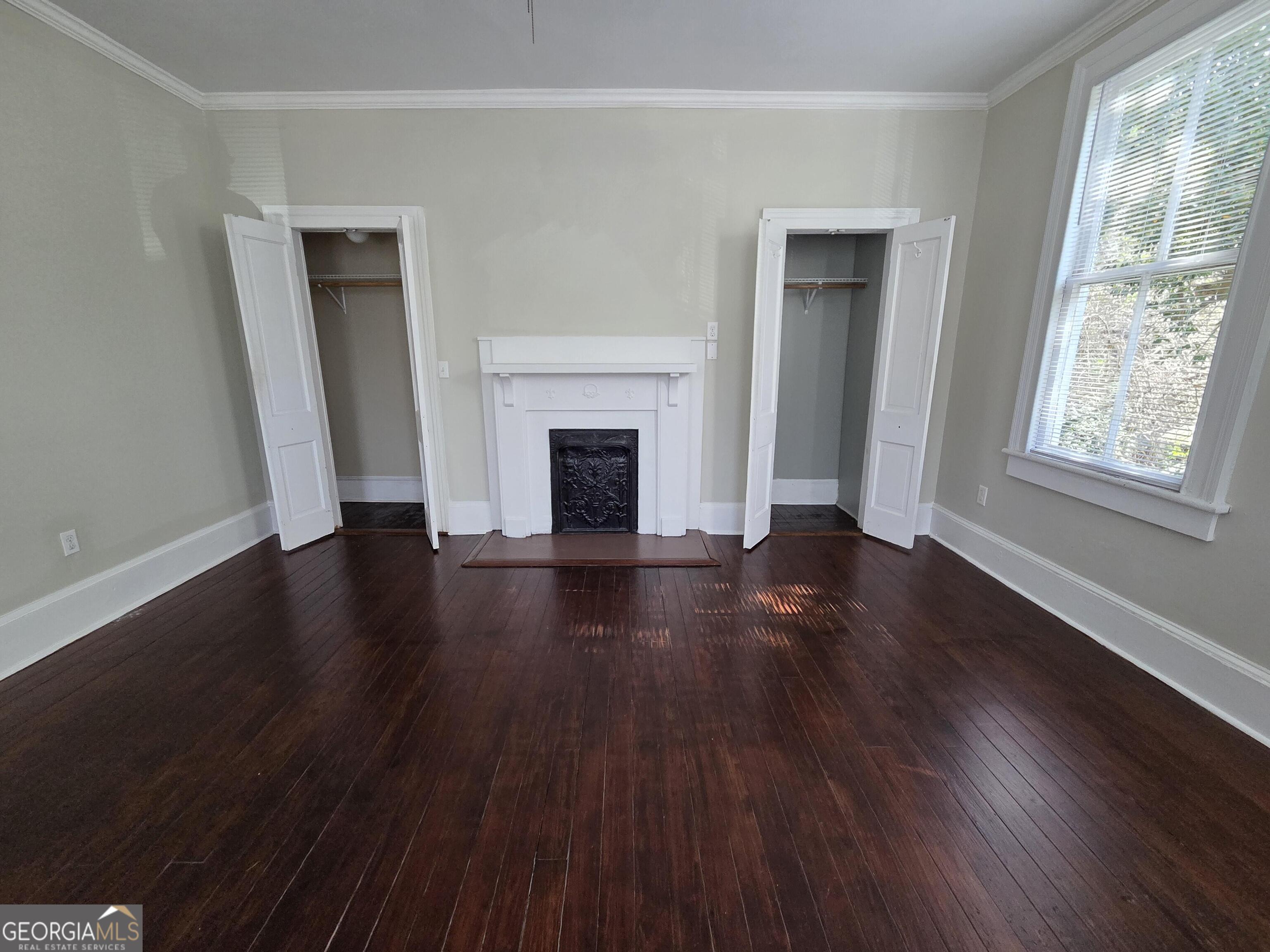 520 Ellis Street Brunswick, GA 31520 - Photo 42 of 48 an empty room with wooden floor fireplace and windows