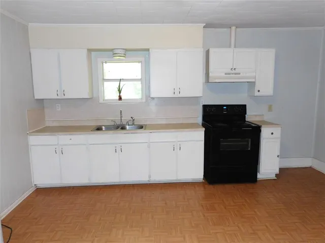 a kitchen with granite countertop white cabinets and black appliances