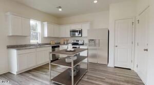 161 Bedstone Way Clayton, NC 27520 - Photo 5 of 14 a kitchen with a refrigerator and white cabinets