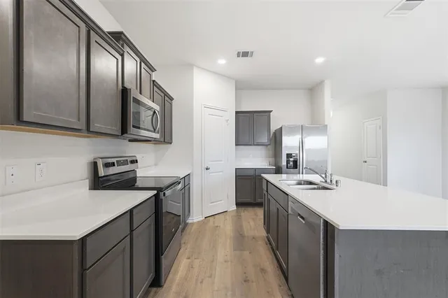 a kitchen with stainless steel appliances granite countertop a sink stove microwave refrigerator and cabinets