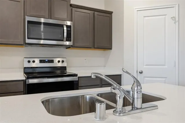 a kitchen with a sink and a stove top oven