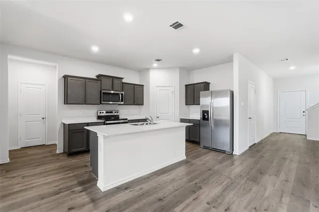 a kitchen with stainless steel appliances a refrigerator stove a sink and a microwave