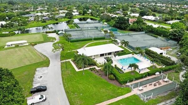 a view of a house with a big yard and palm trees