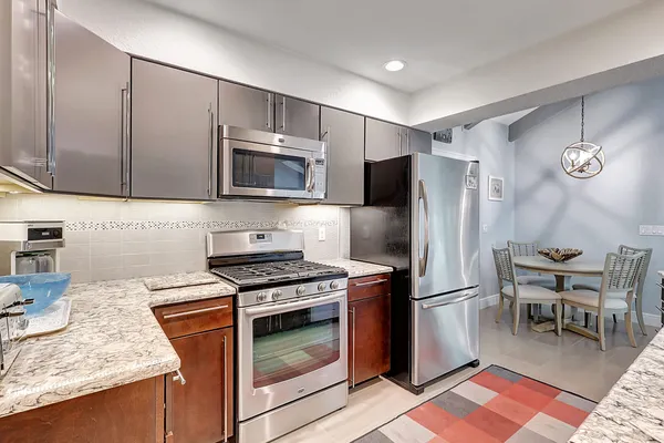 a kitchen with granite countertop cabinets and steel stainless steel appliances with wooden floor