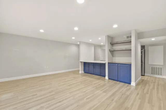 a view of an empty room with a kitchen