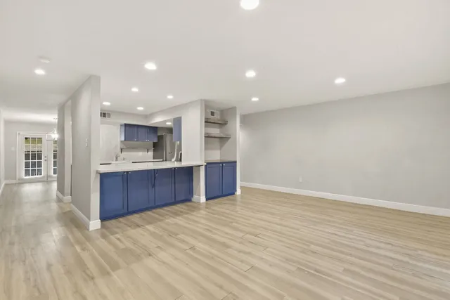 a view of kitchen with kitchen island stainless steel appliances wooden cabinets and window