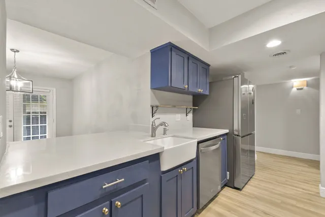 a kitchen with a sink cabinets and wooden floor