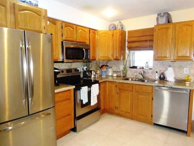3202 Northeast 7th Place Pompano Beach, FL 33062 - Photo 3 of 7 a kitchen with stainless steel appliances a refrigerator sink and microwave