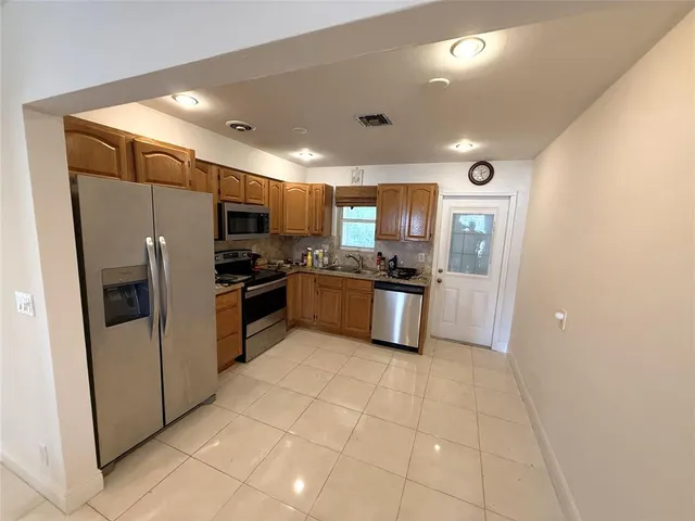 a kitchen with stainless steel appliances a refrigerator and a stove top oven
