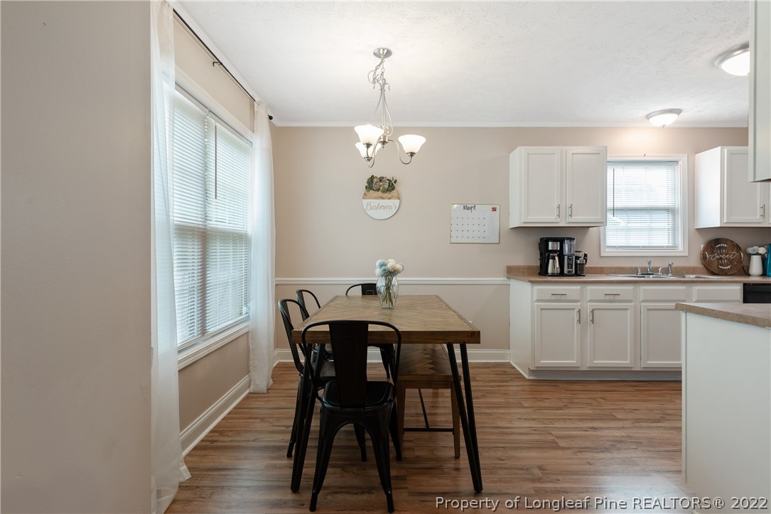191 Quarry Lane Raeford, NC 28376 - Photo 12 of 42 a kitchen with stainless steel appliances a dining table chairs and wooden floor