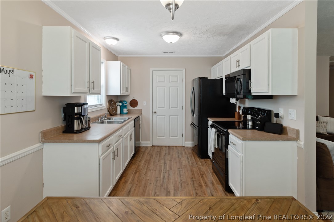 191 Quarry Lane Raeford, NC 28376 - Photo 14 of 42 a kitchen with a sink a counter top space stainless steel appliances and cabinets