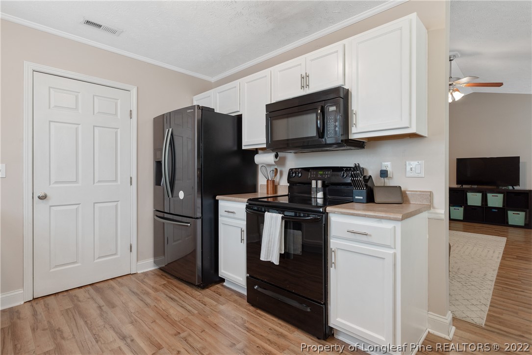 191 Quarry Lane Raeford, NC 28376 - Photo 16 of 42 a kitchen with stainless steel appliances granite countertop a refrigerator stove and white cabinets