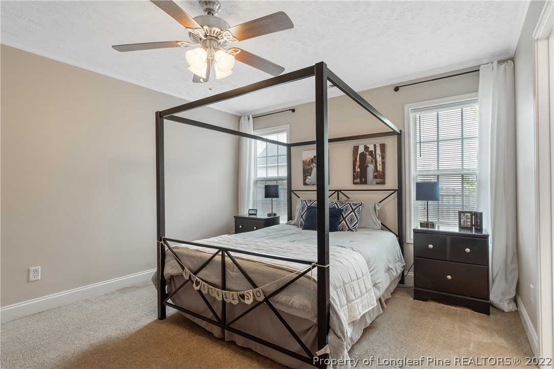 191 Quarry Lane Raeford, NC 28376 - Photo 24 of 42 a bedroom with a bed and a chandelier