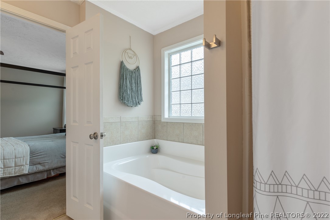 191 Quarry Lane Raeford, NC 28376 - Photo 26 of 42 a en suite bathroom with a tub shower and window