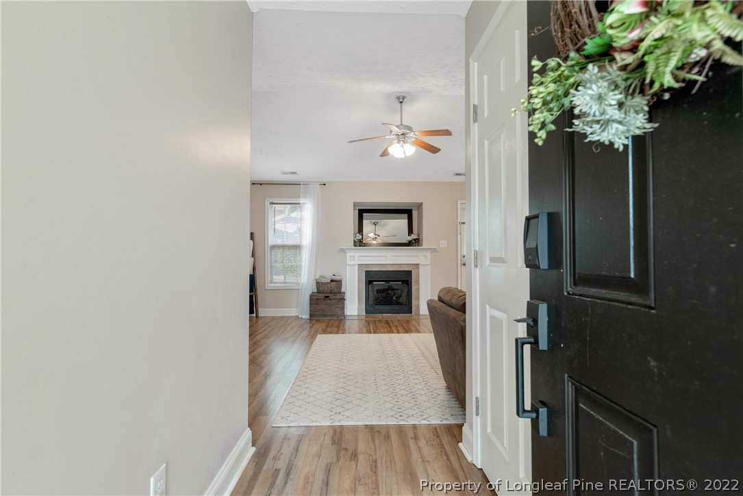 191 Quarry Lane Raeford, NC 28376 - Photo 5 of 42 view of a hallway with wooden floor and a fireplace