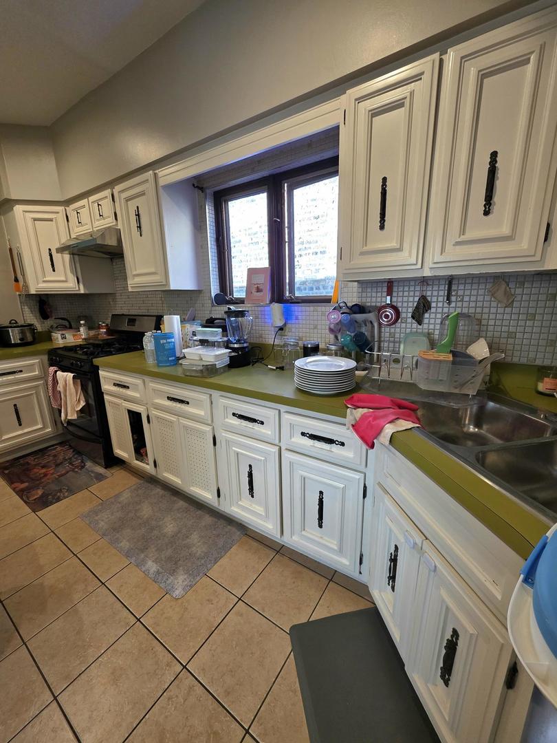 6420 North Artesian Avenue, Unit 2 Chicago, IL 60645 - Photo 4 of 8 a kitchen with stainless steel appliances granite countertop a sink stove and cabinets