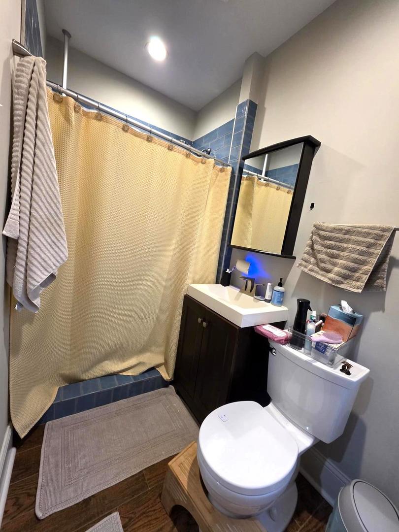 6420 North Artesian Avenue, Unit 2 Chicago, IL 60645 - Photo 6 of 8 a bathroom with a toilet sink and mirror
