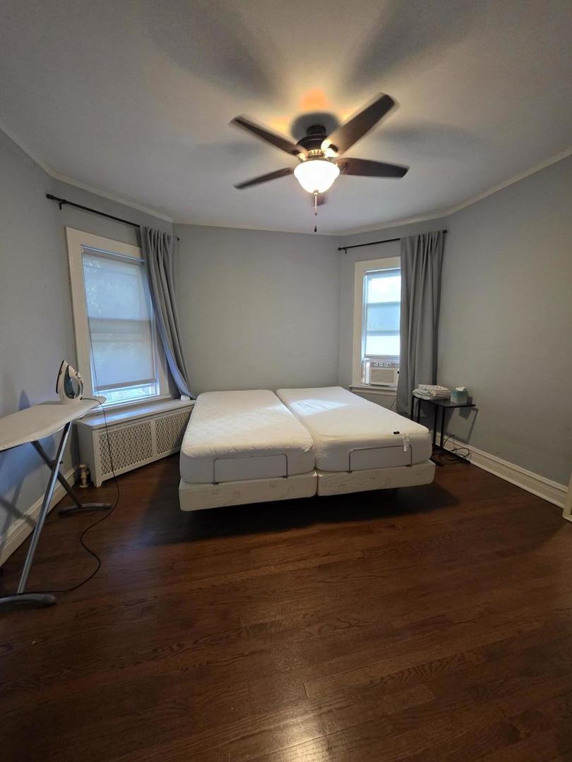 6420 North Artesian Avenue, Unit 2 Chicago, IL 60645 - Photo 8 of 8 a bedroom with a bed and a chandelier