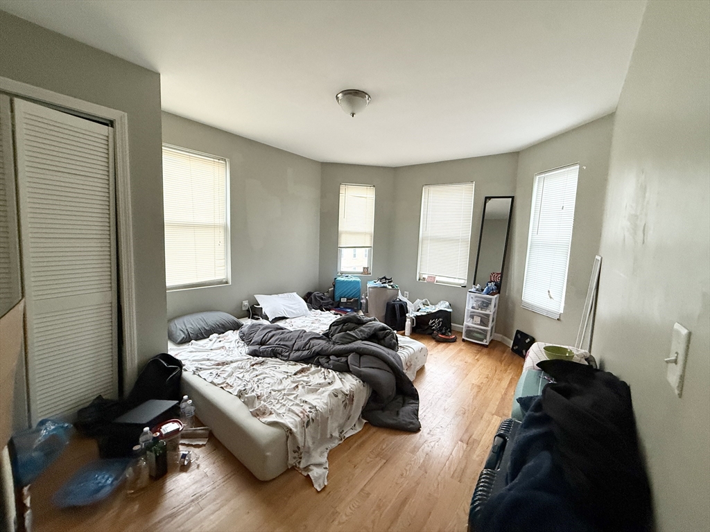 3977 Washington Street, Unit 3 Boston, MA 02131 - Photo 1 of 11 a bedroom with a bed window and couch