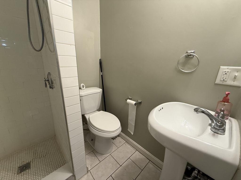 3977 Washington Street, Unit 3 Boston, MA 02131 - Photo 8 of 11 a bathroom with a sink a toilet and a mirror