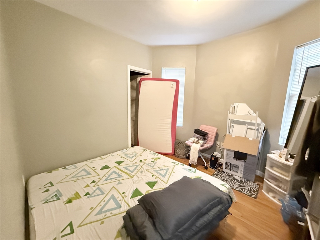 3977 Washington Street, Unit 3 Boston, MA 02131 - Photo 9 of 11 a bedroom with a bed and wooden floor