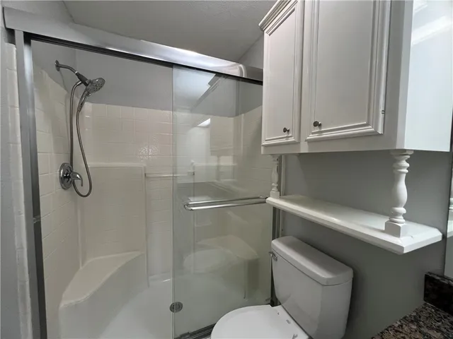 a bathroom with a shower a toilet and sink