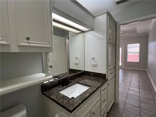 a bathroom with a granite countertop sink a toilet and mirror