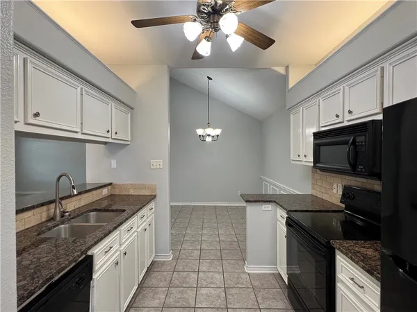 a kitchen with stainless steel appliances granite countertop a sink a stove oven and cabinets