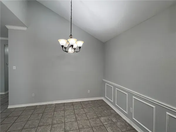 a view of an empty room with chandelier fan