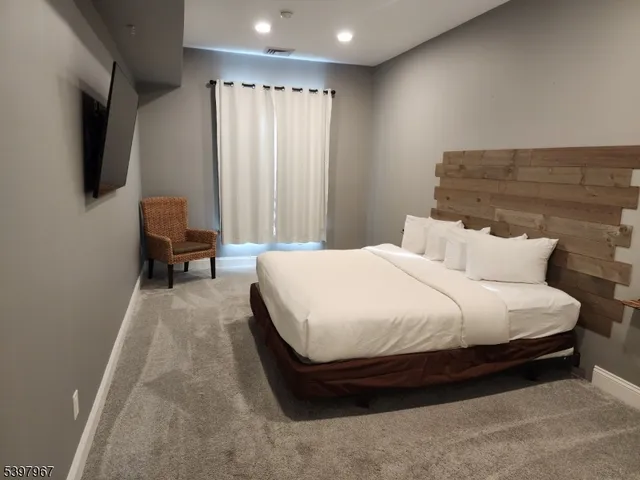 a spacious bedroom with a bed and chair