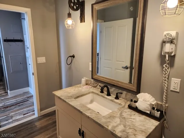a bathroom with a granite countertop sink and a mirror