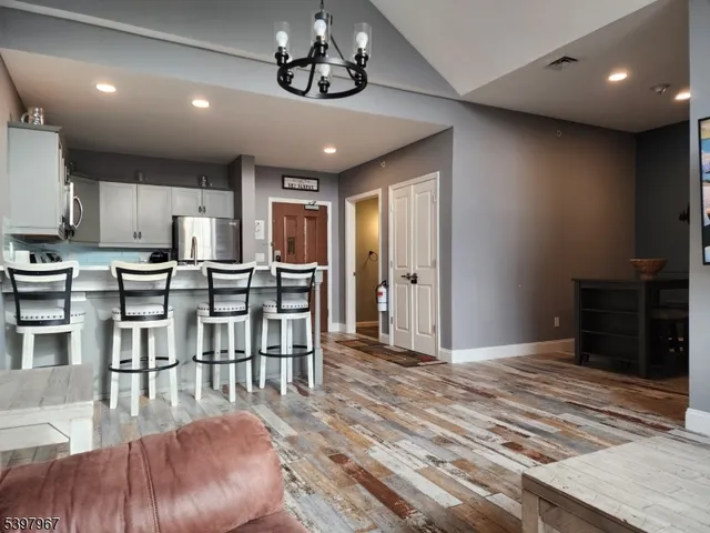 a view of a dining room with furniture a kitchen and chandelier