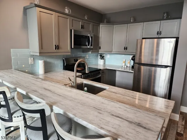 a kitchen with stainless steel appliances a refrigerator stove microwave and sink