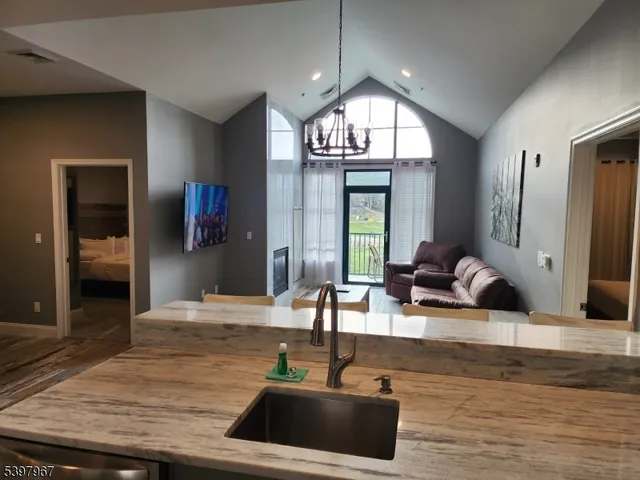 a living room with kitchen island furniture and a chandelier