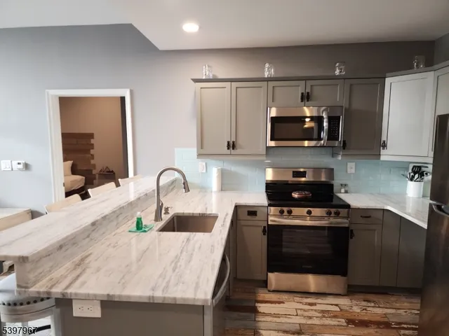 a kitchen with kitchen island a sink stove top oven and refrigerator