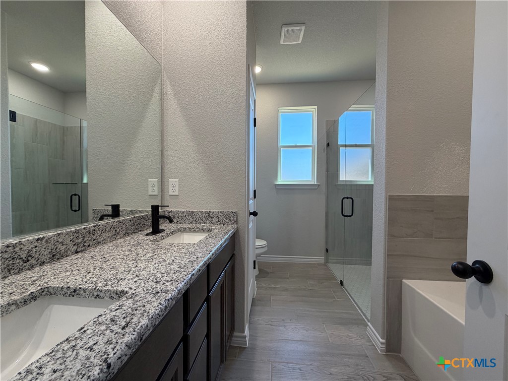 3008 Seeker Street Killeen, TX 76549 - Photo 13 of 25 a bathroom with a granite countertop sink and a mirror