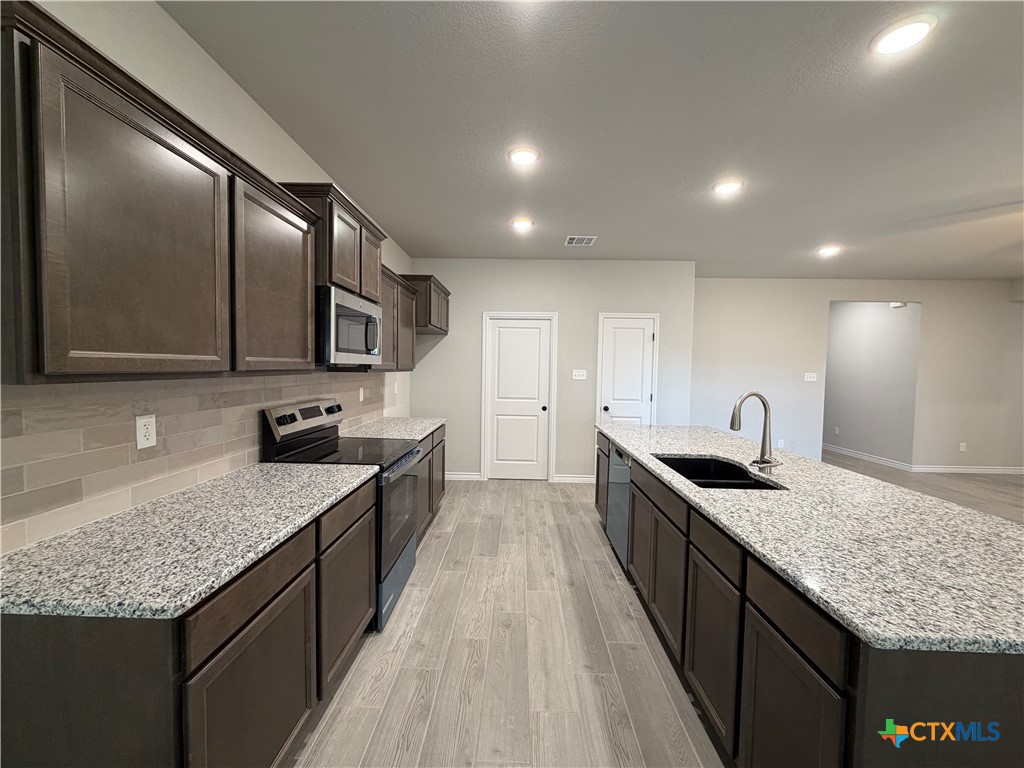 3008 Seeker Street Killeen, TX 76549 - Photo 6 of 25 a kitchen with granite countertop stainless steel appliances and sink
