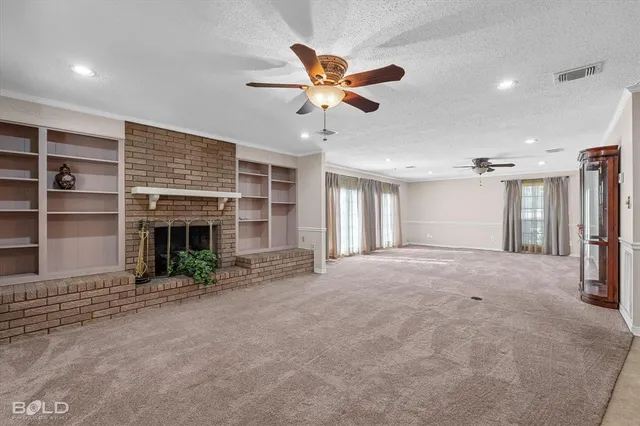 a view of an empty room with a fireplace and a window