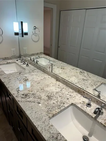 a kitchen with stainless steel appliances granite countertop a refrigerator a stove and a sink with wooden cabinets