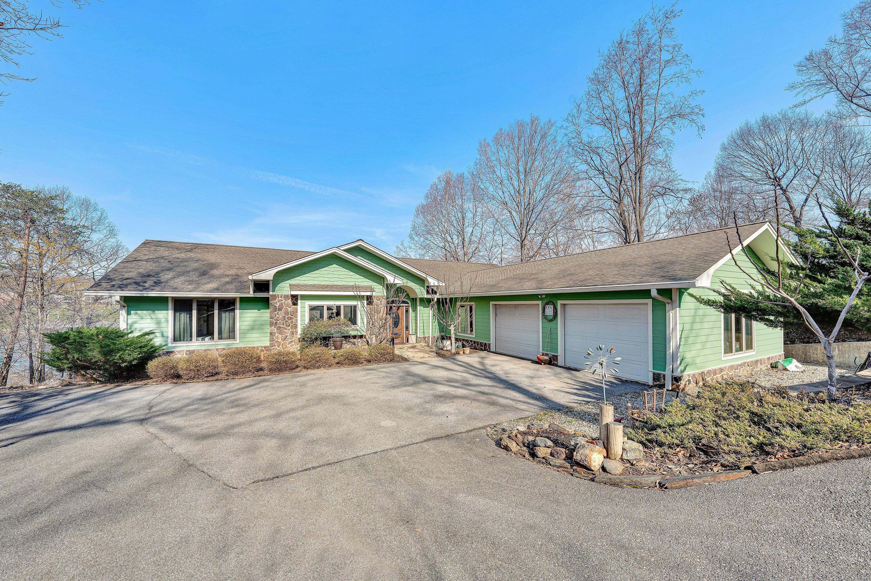 23 Waterpoint Court Moneta, VA 24121 - Photo 1 of 38 a front view of a house with a garden and trees