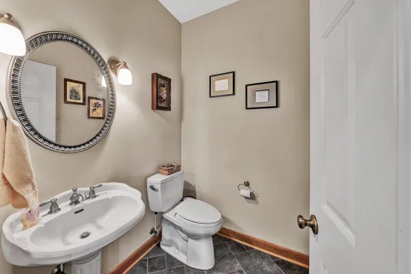 a bathroom with a toilet a sink and mirror