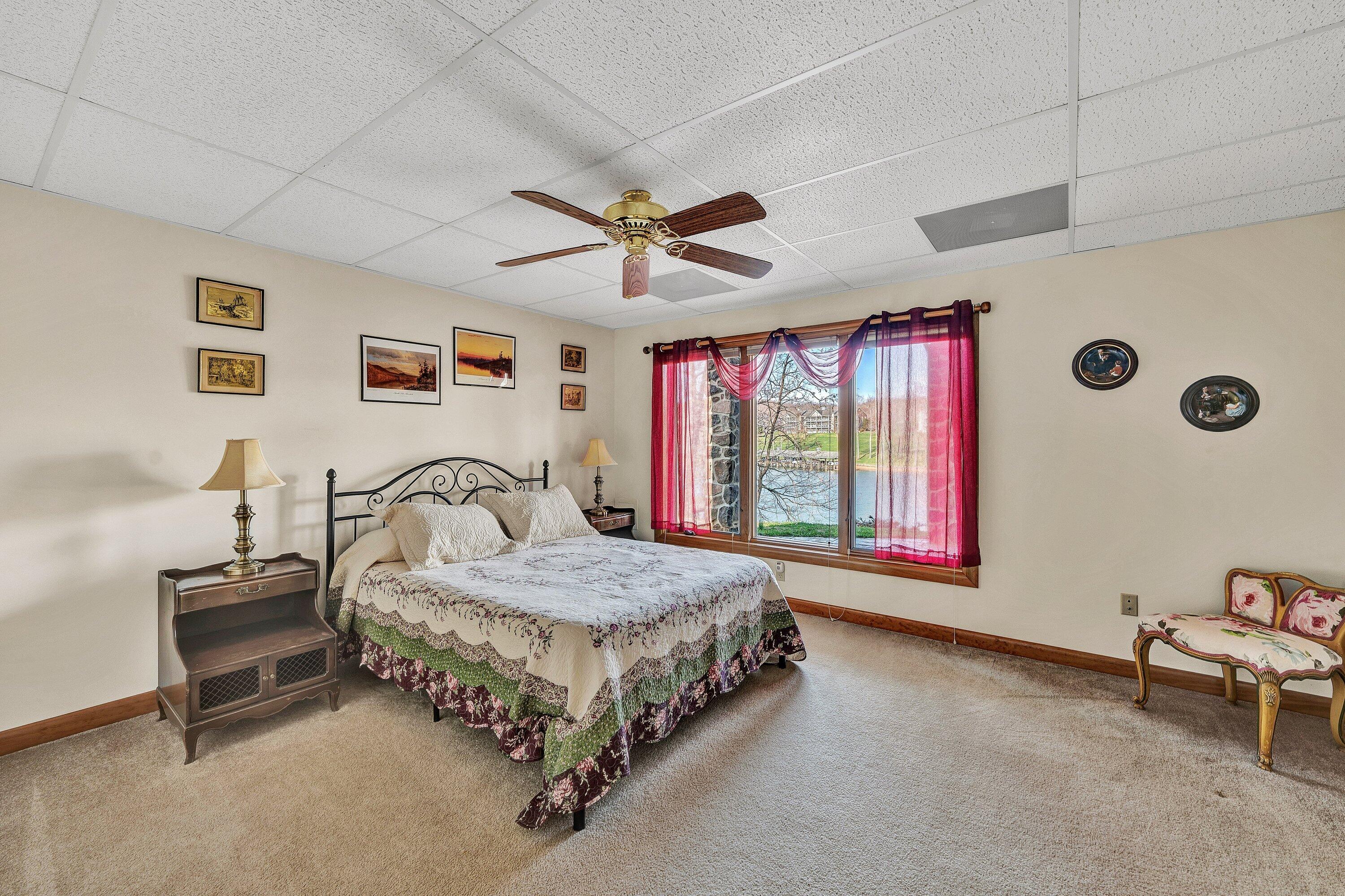 23 Waterpoint Court Moneta, VA 24121 - Photo 27 of 38 a spacious bedroom with a bed and a chandelier