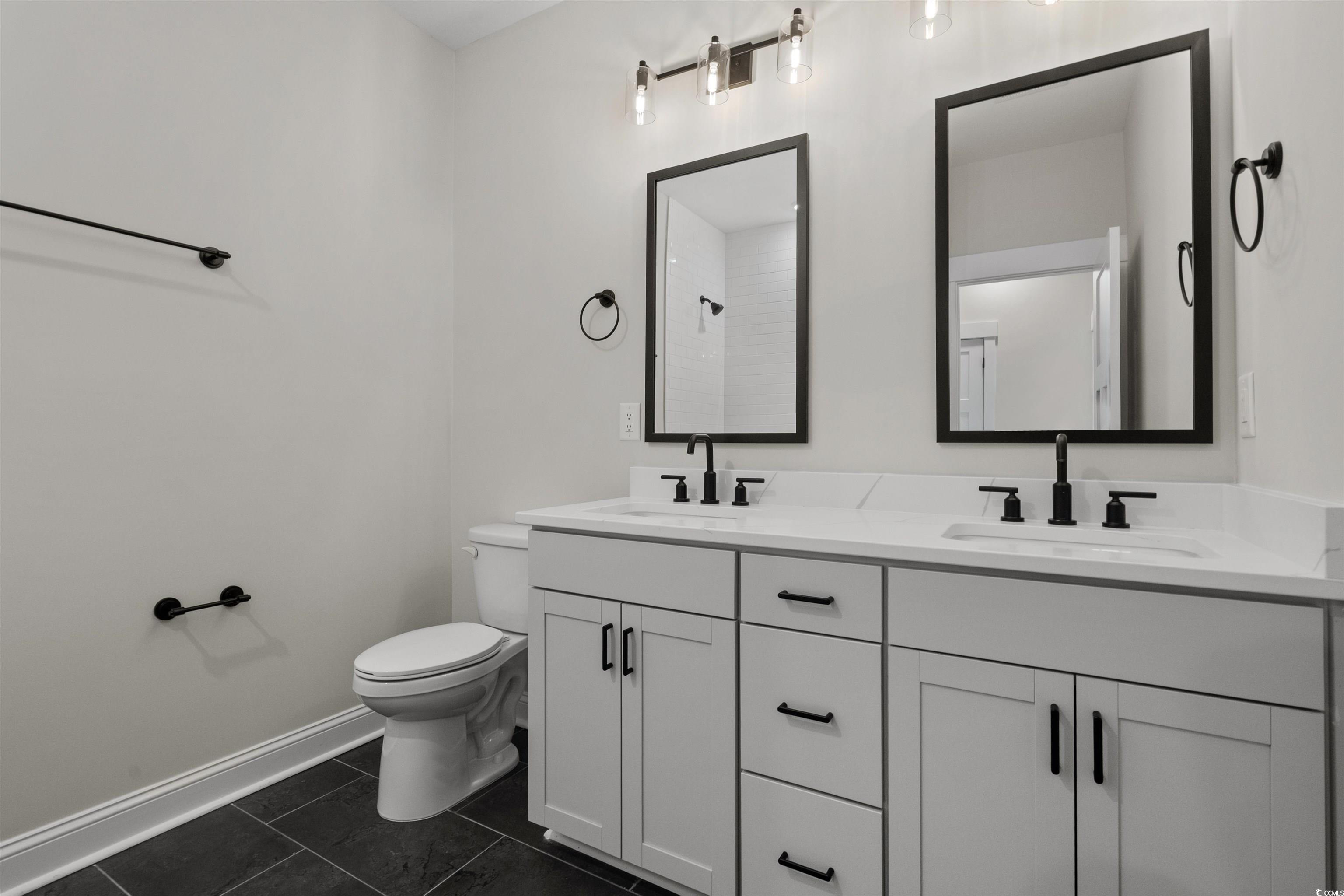 8472 Duke Place, Unit 30 Myrtle Beach, SC 29572 - Photo 33 of 40 Full bath featuring double vanity, dark tile patterned floors, and a shower