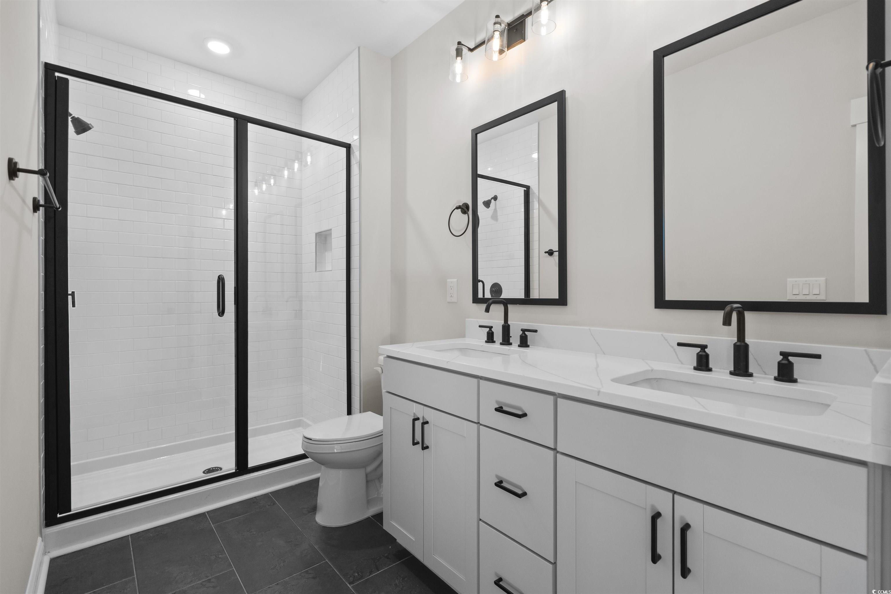 8472 Duke Place, Unit 30 Myrtle Beach, SC 29572 - Photo 39 of 40 Full bathroom with double vanity, a stall shower, dark tile patterned flooring, and recessed lighting
