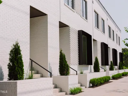a front view of a house with a yard and potted plants