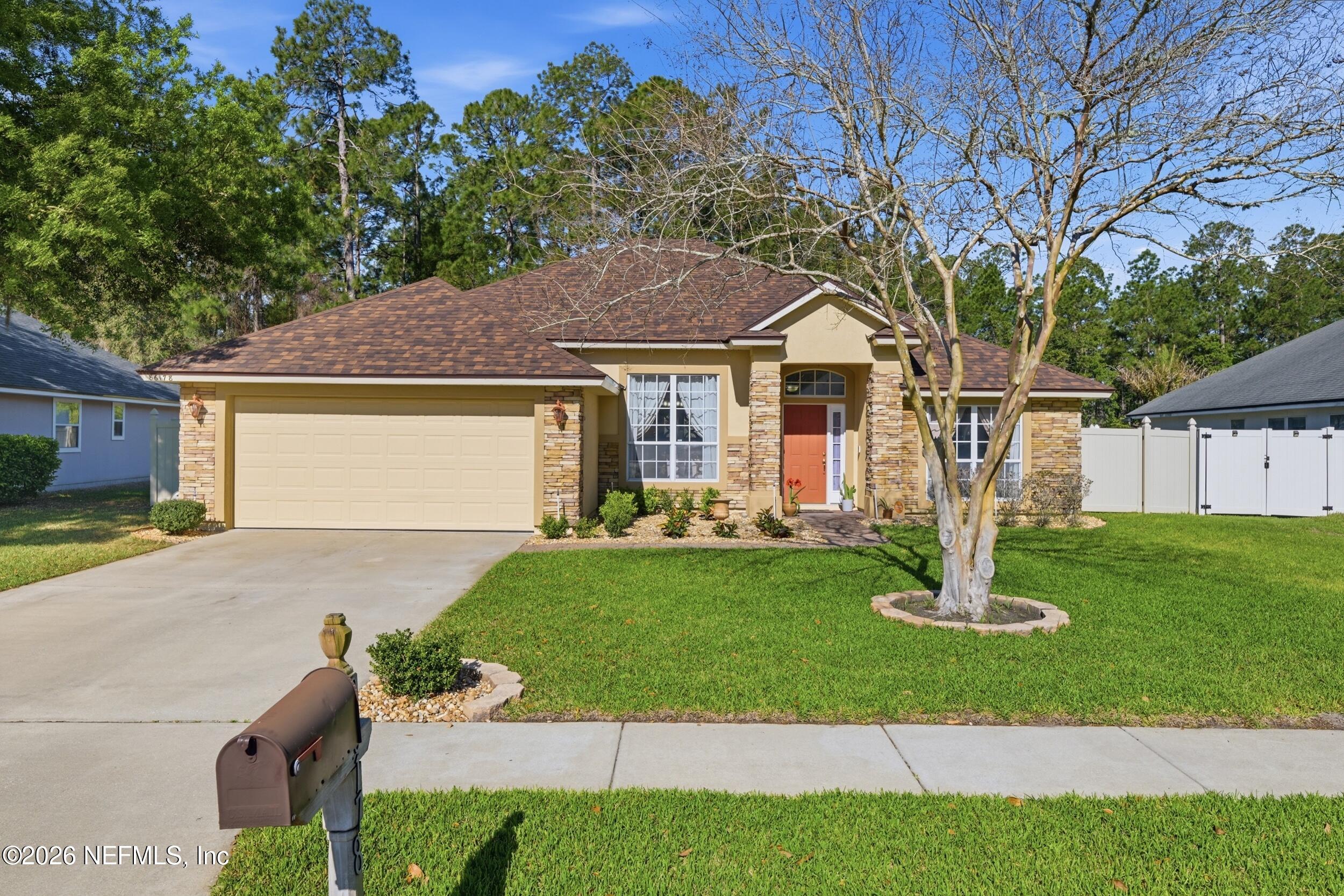 86178 Sand Hickory Trail Yulee, FL 32097 - Photo 1 of 23 a front view of a house with a yard