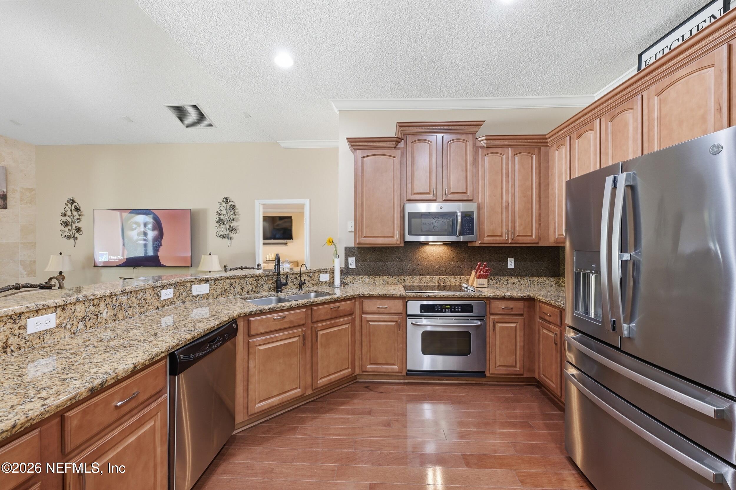 86178 Sand Hickory Trail Yulee, FL 32097 - Photo 8 of 23 a kitchen with stainless steel appliances granite countertop a sink stove refrigerator and cabinets