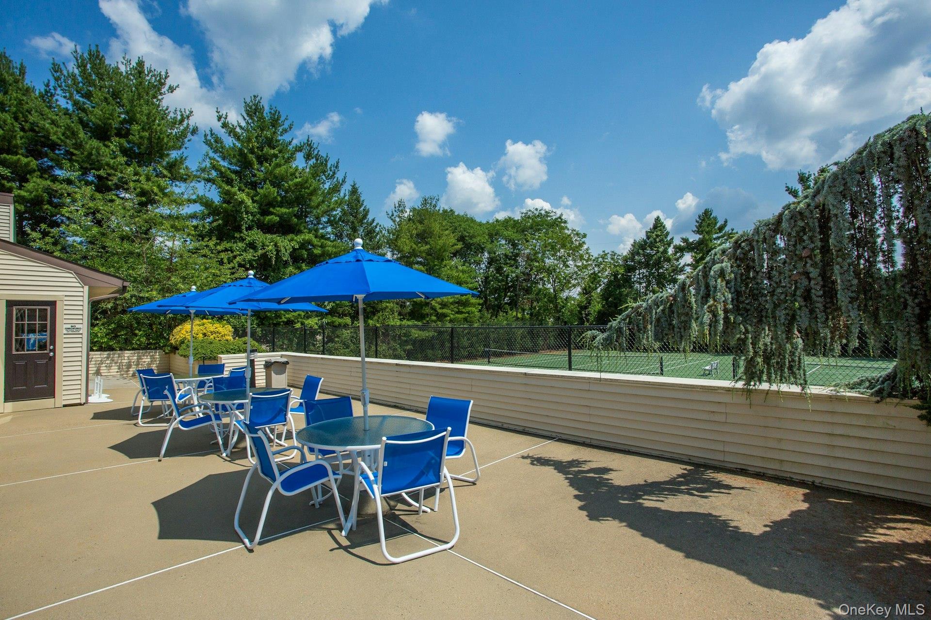 232 Linnet Court Manhasset, NY 11030 - Photo 25 of 28 a view of a roof deck with table and chairs under an umbrella