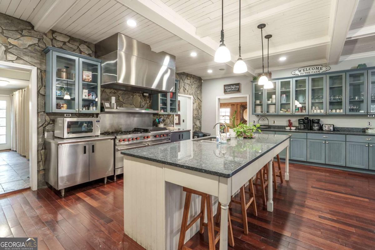 7527 Highway 326 Commerce, GA 30530 - Photo 47 of 100 a kitchen with stainless steel appliances granite countertop a sink a stove and a wooden floors